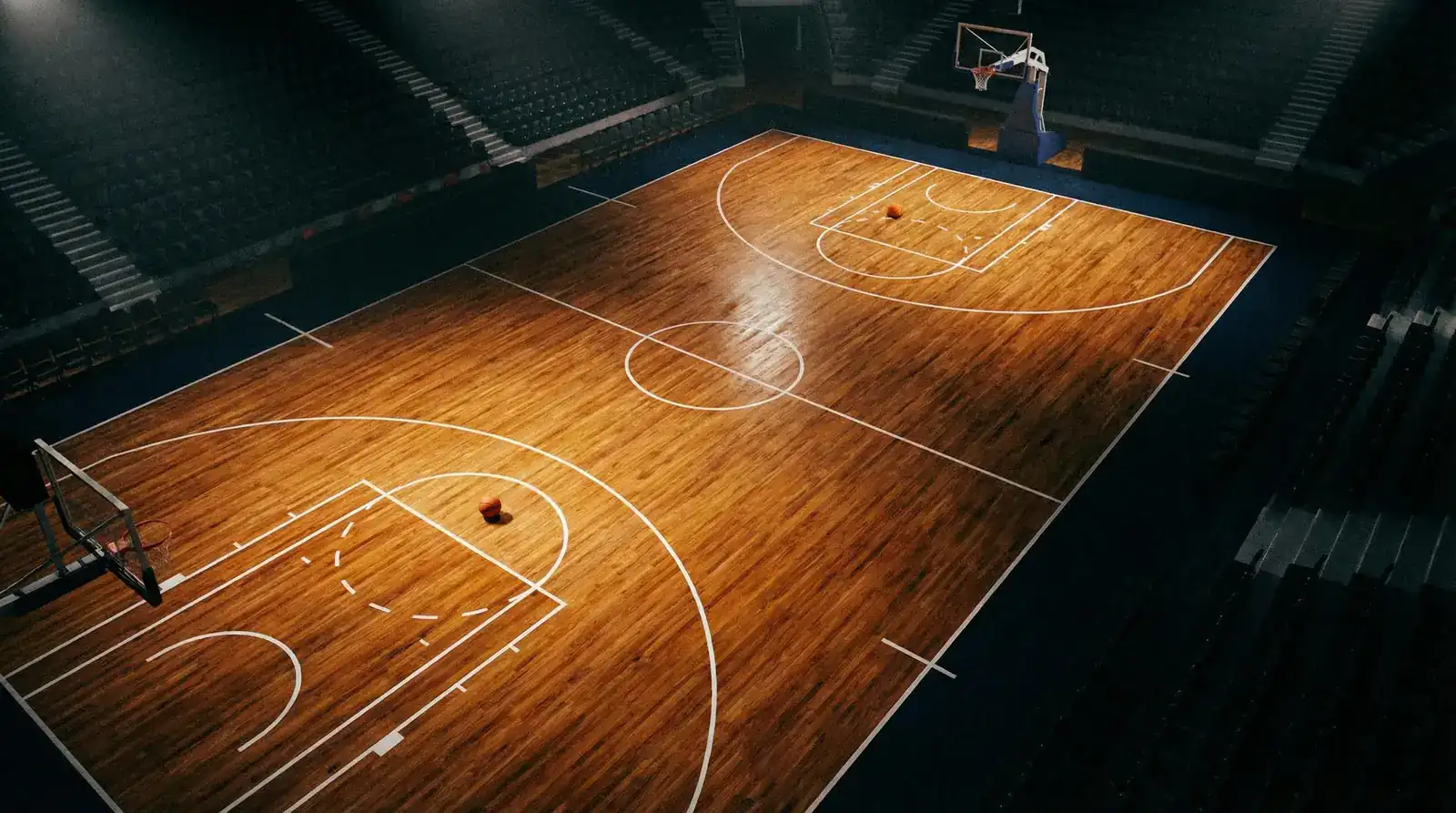 Professional basketball court from above showing hardwood floor with court lines and basketball near free-throw line
